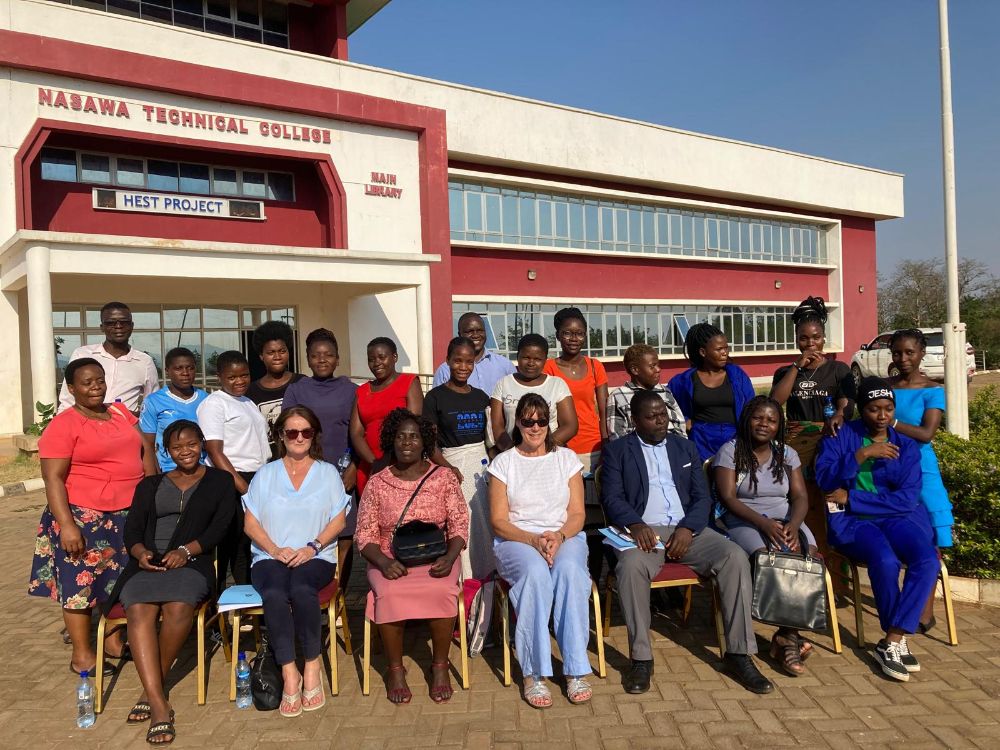 SERC staff with partners in Malawi seated outside a college building